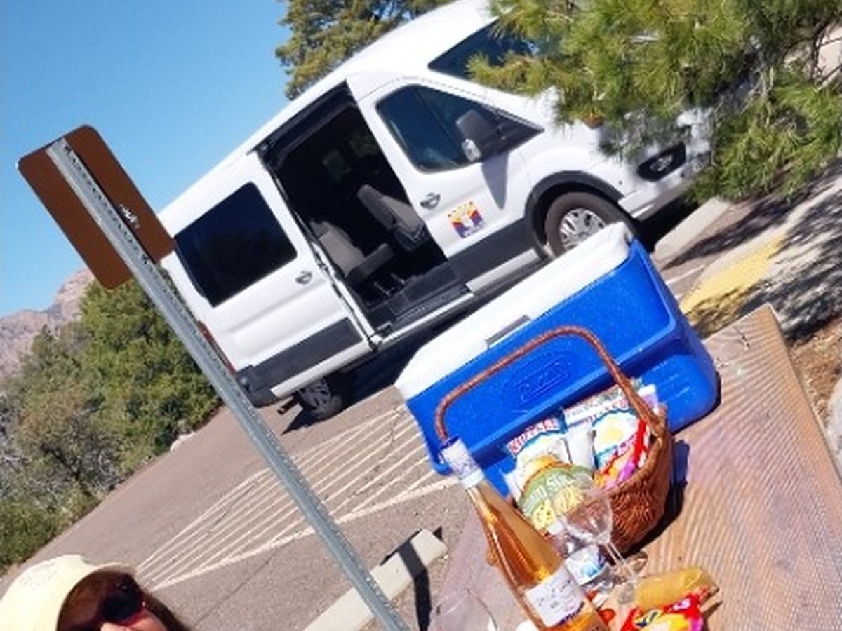 A guest enjoying a picnic stop with the Sonoita Wine Tours van